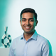 Headshot of a smiling young professional against a bright white background, conveying trust and happiness.